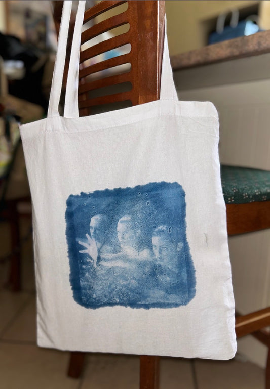 White canvas tote bag with H2O cyanotype print hanging on wooden chair